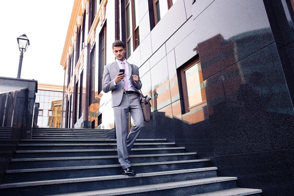 Businessman walking on the stairs and using smartphone outdoors - How To Draw In An Aquarius Man Via Text