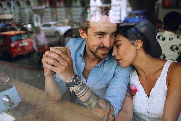 Dreamy couple resting in cafe behind the window at sunny day - how does an aquarius man show his love